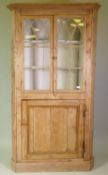A Georgian stripped pine barrel back corner cupboard, two glazed doors with lancet shaped glazing