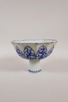 A Chinese blue and white porcelain stem bowl with lobed rim and decorative panels depicting dragons,
