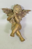 A vintage gilt composition figure of a seated putto playing the pipes, 47cm high