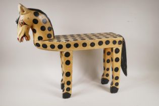A vintage folk art painted wood table/stool in the form of a spotted pony, 56cm high, 66cm long