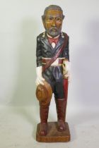 A folk art carved and painted wood figure of a Latin American military officer, 103cm high