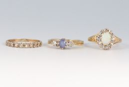 A 9ct gold half eternity ring set white stones, a 9ct ring set two diamonds and a pale blue stone,