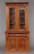 A Victorian mahogany bookcase on cabinet with moulded cornice, fitted adjustable shelves enclosed by