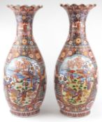Pair of very large floor standing Japanese Imari vases decorated with panels of figures in