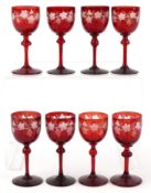 Eight antique Bohemian cranberry glasses etched with grapevines, 15cm high.