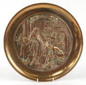 Dutch gilt bronze charger having repoussé decoration of figures in a workshop, titled The Shoemaker,