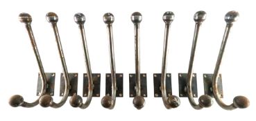 SET OF EIGHT 20TH CENTURY STEEL TWO-HOOK ATOMIC STYLE WALL COAT HANGERS