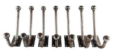 SET OF SEVEN 20TH CENTURY STEEL TWO-HOOK ATOMIC STYLE WALL COAT HANGERS
