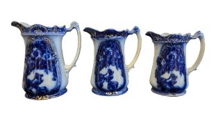 THREE EARLY 20TH CENTURY IRONSTONE CHINA GRADUATING BLUE & WHITE JUGS