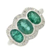 An emerald & diamond cluster ring