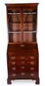 A George III red walnut bureau bookcase, with lancet bar glazed doors above the fall front with a