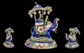 A Small Sized Antique Silver & Enamel Elephant Group, with figures aloft, mounted on an oval base.