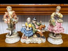 Three Capodimonte Figures, two male and female holding flowers, and another with tramps on a