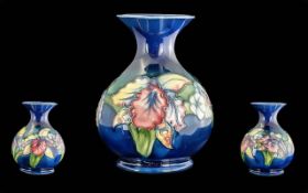William Moorcroft Signed Hand Painted and Tube lined Globular Shaped Vase ' Orchids ' Design on Blue