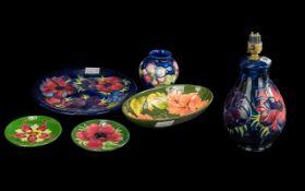 Six Pieces of Moorcroft Pottery, to include a 10'' blue ground plate, two coasters, a bowl, small