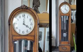 An Early 20thC Golden Oak Art Deco Long Case Clock with silvered dial and Arabic numerals. Glazed