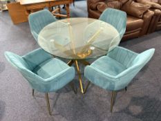 Circular Glass Topped Table raised on crossed gold tone legs, with four matching chairs