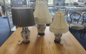 Three Table Lamps, comprising two matching ceramic floral lamps, both with shades, one overall