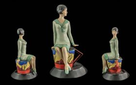 Kevin Francis Ceramics Figure of Clarice Cliff, sitting on a tea cup and saucer. Modelled by Andy