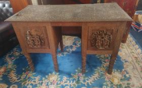 An Unusual Carved Burmese Kneehole Antique Desk Style Sideboard, profusely carved with deity figures