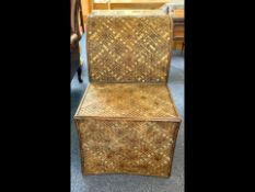 An Indian Pidha Low Chair, featuring a carved wooden frame with intricate woven seating, with angled
