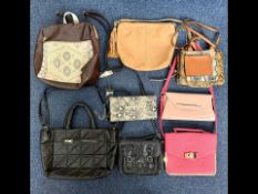 Box of Handbags, to include a tan leather shoulder bag with tassels, black satchel style bag, pink