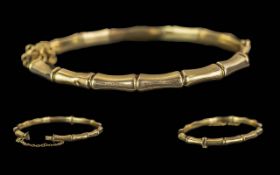 Ladies - Pleasing 9ct Gold Bamboo Design Hinged Bangle with Safety Chain. Marked 9ct. Weight 9.2