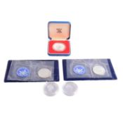 Five silver coins, UK, Solomon Islands, and USA.