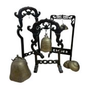 Three Chinese brass bells on hardwood stands, together with another two bells, tallest stand 52cm.