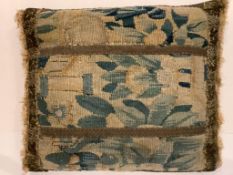 A 19th century verdure tapestry cushion, gilt braided, fringed with damask backing. 39cm x 33cm.