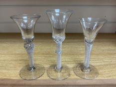 Three George III wine glasses with air twist stems, one with applied vermicular collar, largest 18cm