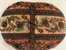 A 19th Century oval heavily beaded Berlin beadwork cushion, worked in rows of scrolling floral