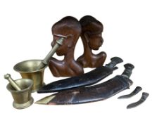 Two African carved hardwood busts, two brass pestle and mortars and two kukri knives, largest 42cm