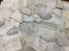 A large collection of crochet edged linen table cloths including tea and dinner sized cloths.