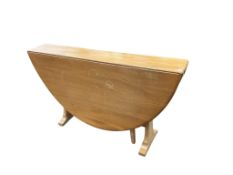 An Ercol elm drop leaf dining table, width 140cm extended, depth 137cm, height 72cm