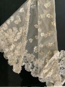 A late 19th century Brussels appliqué bobbin lace on net triangular wedding shawl, worked with a