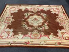 A 19th century Aubusson tapestry rug, woven with a central floral cartouche and swagged rose