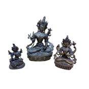 A Nepalese jewelled bronze Buddha, height 21cm and two similar smaller.