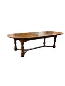 An 18th century style oval oak extending dining table in the manner of Titchmarsh & Goodwin, 288cm