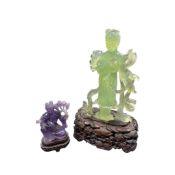 Two Chinese Guanyin figures, one carved in green stone, the other in amethyst quartz, both raised on