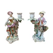 A pair of Derby floral encrusted porcelain figural candlesticks, 25cm high
