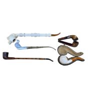 A large novelty carved meerschaum pipe, and four other pipes, the first 38cm
