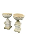 A pair of reconstituted stone circular garden planters on square pedestals, diameter 54cm, height