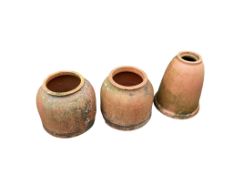 Five terracotta rhubarb forcers and a marble mortar, largest 60cm high