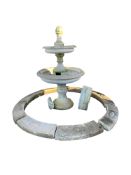A circular reconstituted stone three tier garden fountain, height 174cm with floral surround