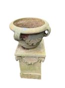 A circular glazed earthenware garden planter on an earthenware stand, moulded with rams' heads,