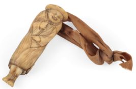 A Japanese antler netsuke of a foreigner, 18th / 19th century, depicted in a cloak and straw hat