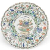 A Chinese famille verte lobed dish, Kangxi period, central well enamelled with a basket of flowers