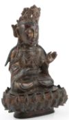 A Chinese late Ming bronze figure of Guanyin, early 17th century, seated wearing jewellery and an