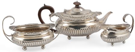 A late Victorian demi-fluted silver three piece tea set, by The Barnards, of oval form, with